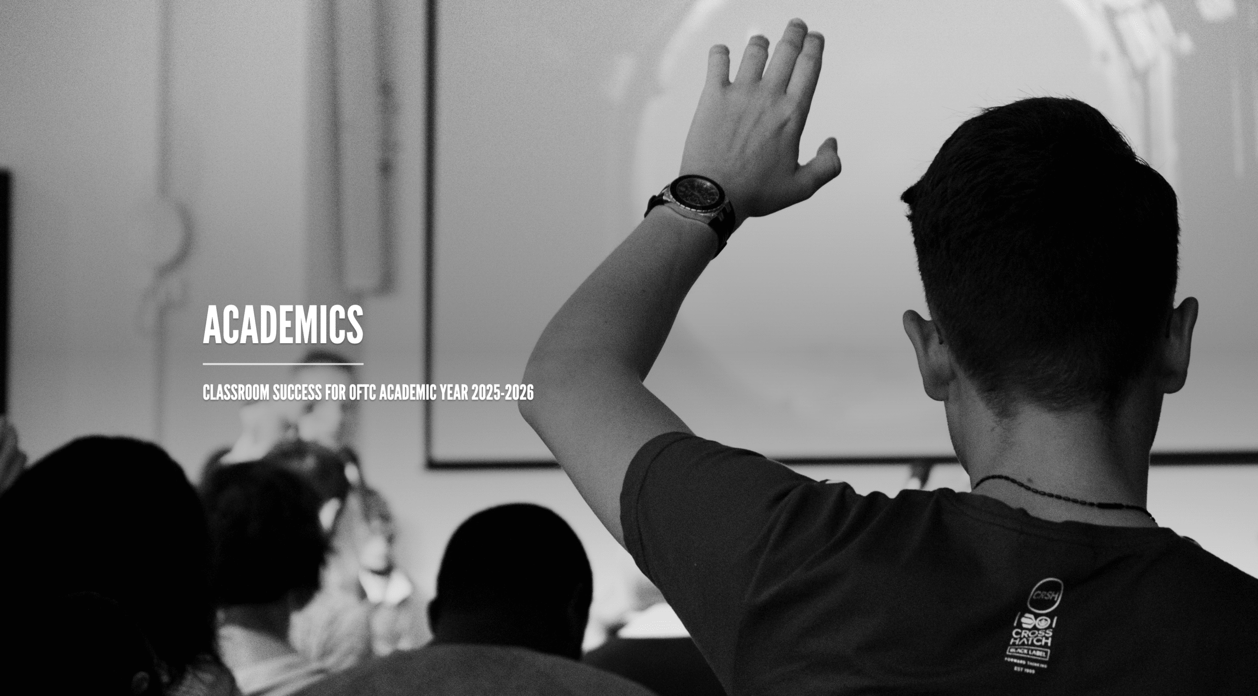 A student raises his hand in a classroom, facing a whiteboard, with the words Academics and Classroom success for OTC academic year 2025-2026 displayed on the image.