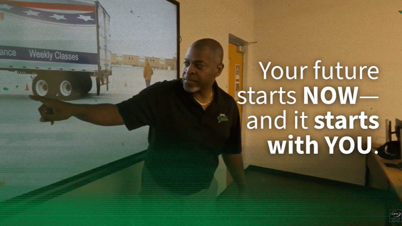 A man points at a screen displaying a truck image in a classroom. Text on the image reads: Your future starts NOW—and it starts with YOU.