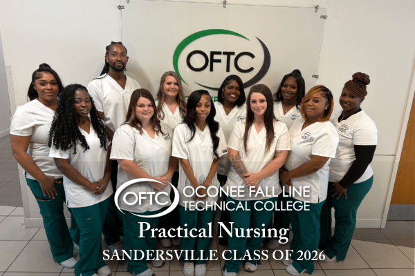 Eleven nursing students in white uniforms stand together and smile for a photo in front of an OFTC logo wall. Text reads: OFTC Practical Nursing Sandersville Class of 2026.