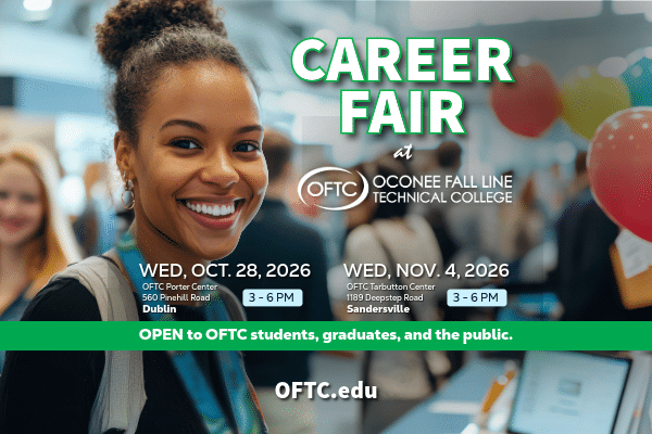 A smiling student at a career fair stands near signage displaying event details and dates for Oconee Fall Line Technical College’s upcoming career fairs in Dublin and Sandersville. Information on the sign notes the events are open to students, graduates, and the public.