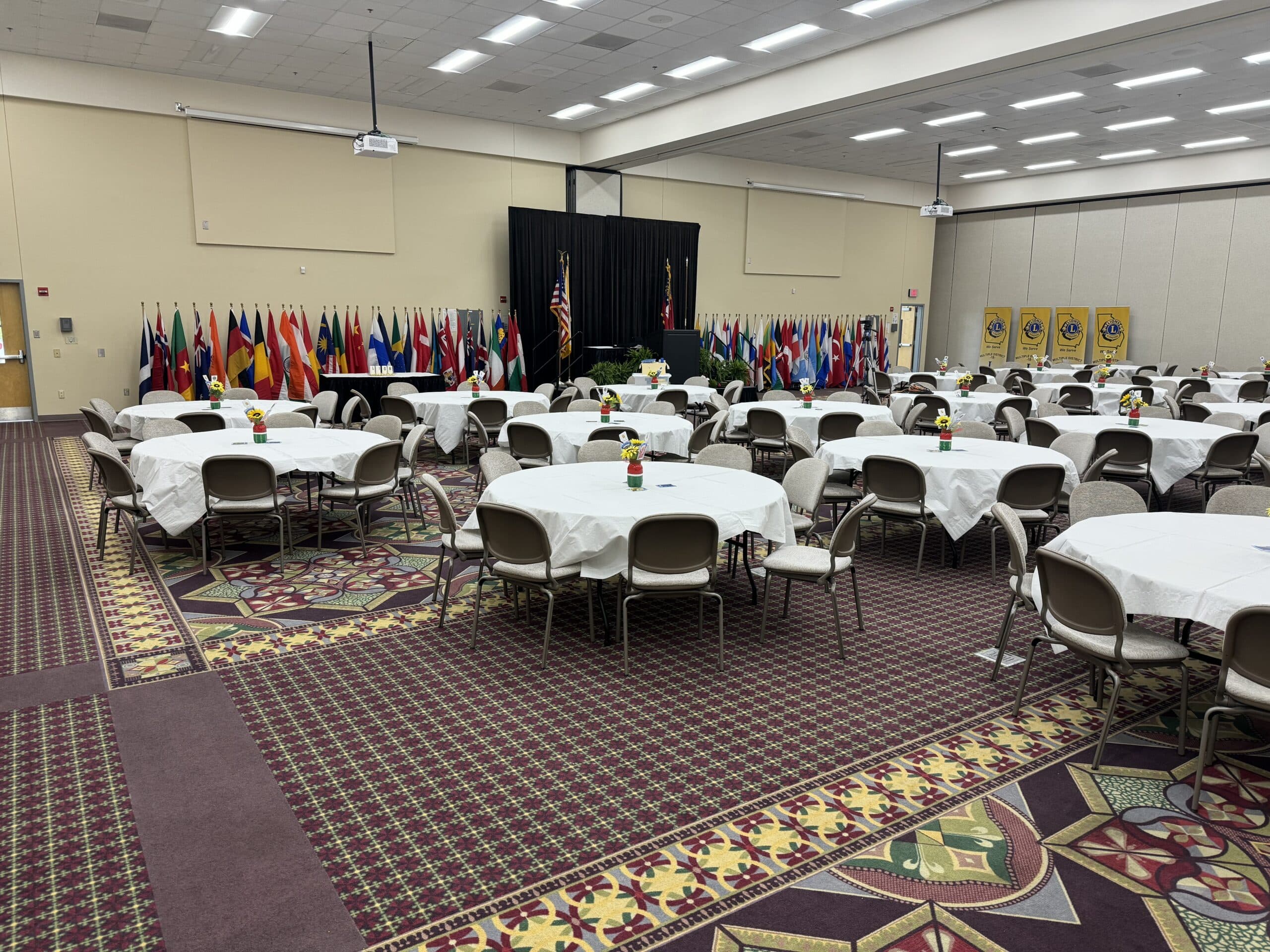 Dublin's Porter Center set up with round tables covered in white tablecloths, with rows of international flags displayed against the back wall.