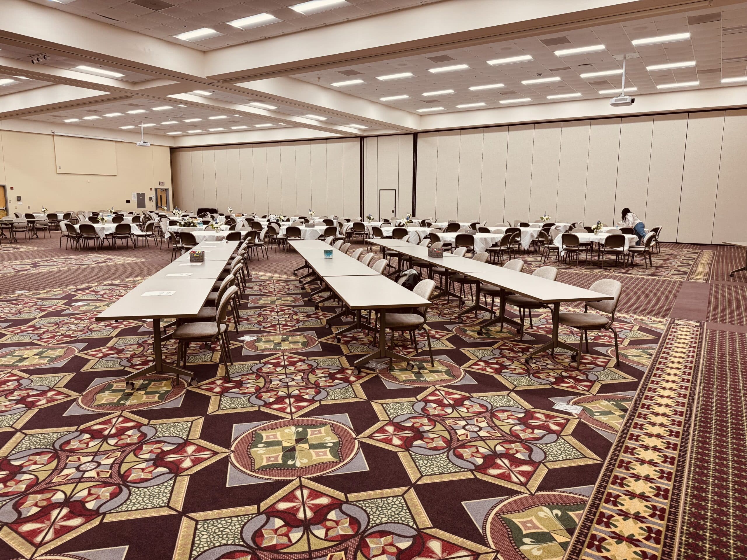 Dublin's Porter Center setup for a business meeting and luncheon, featuring rows of long rectangular tables and round tables set with chairs.