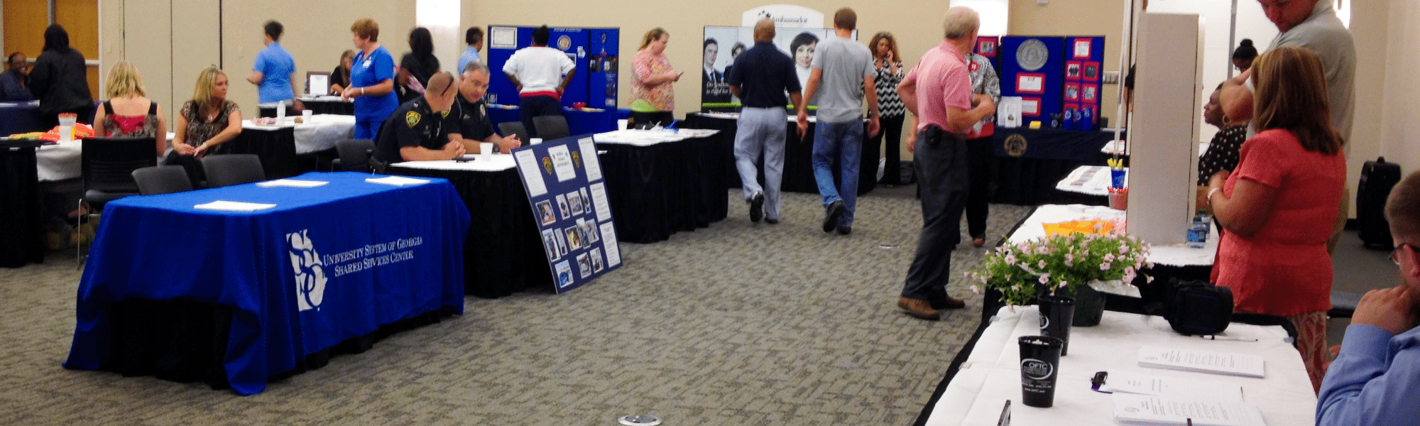 People browse booths and talk at a University System of Georgia career fair.